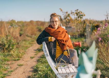 Frau mit Brille auf einer Bank in der Natur